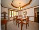 Formal dining room featuring a tray ceiling, chandelier, and dining set at 7732 Ashtree Dr, Indianapolis, IN 46259
