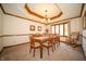 Traditional dining room showcasing a wood table, chairs, chandelier, and a rocking chair near a window at 7732 Ashtree Dr, Indianapolis, IN 46259