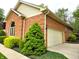Brick house with a two-car garage, lush greenery, and manicured landscaping at 7732 Ashtree Dr, Indianapolis, IN 46259