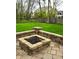 A cozy stone fire pit features ample space and is nestled on a stone paved patio with a large backyard at 7732 Ashtree Dr, Indianapolis, IN 46259