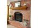 Cozy fireplace with brick surround and a wooden mantel, perfect for creating a warm and inviting atmosphere at 7732 Ashtree Dr, Indianapolis, IN 46259