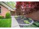 Inviting entryway with a red maple tree, brick facade, and charming front porch at 7732 Ashtree Dr, Indianapolis, IN 46259