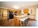 Kitchen view showcasing the breakfast bar with barstools, wooden cabinets and modern black appliances at 7732 Ashtree Dr, Indianapolis, IN 46259