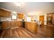 Open kitchen featuring wooden cabinets, an island, modern appliances, and access to dining area and hallway at 7732 Ashtree Dr, Indianapolis, IN 46259