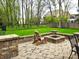 Inviting patio features a stone fire pit, seating area, and lush green lawn perfect for outdoor entertaining at 7732 Ashtree Dr, Indianapolis, IN 46259