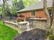 Outdoor patio with a stone fire pit, bar seating and brickwork that provides an ideal space for relaxation at 7732 Ashtree Dr, Indianapolis, IN 46259