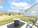 Spacious backyard with a gray fire pit table, Adirondack chairs, and manicured lawn at 811 Harley Ln, Westfield, IN 46074