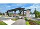 Community entrance featuring stone columns, pergola, American flag, and landscaping at 811 Harley Ln, Westfield, IN 46074