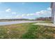 Backyard with grass, an open pond, and concrete patio space by the house at 8818 Tributary Dr, Indianapolis, IN 46259
