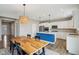 Bright kitchen featuring stainless appliances, white cabinetry, island with quartz counters, and wooden dining table at 8818 Tributary Dr, Indianapolis, IN 46259