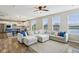 Spacious living room with a large sectional sofa, hardwood floors, and natural light flowing in at 8818 Tributary Dr, Indianapolis, IN 46259