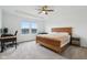Bright main bedroom with tray ceiling, ceiling fan, water view, two windows and a wood bed frame at 8818 Tributary Dr, Indianapolis, IN 46259