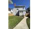Side view of a two-story house showcasing a tidy lawn, fenced yard, and concrete pathway to the entrance at 925 E Main St, Muncie, IN 47305