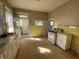 Vintage kitchen with yellow tiled accents, patterned wallpaper, and retro appliances at 925 E Main St, Muncie, IN 47305