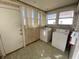 Functional laundry room featuring a washer and dryer, with natural light from adjacent windows, next to a door at 925 E Main St, Muncie, IN 47305