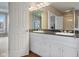 Bathroom with double sinks, black marble countertops, white cabinetry, and vanity lighting at 999 Box Turtle Ct, Columbus, IN 47201