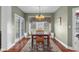 A dining room with wood floors, neutral paint, bright chandelier, and large windows at 999 Box Turtle Ct, Columbus, IN 47201