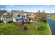 Expansive, waterfront home with lush lawn, deck, and manicured landscaping on a bright, sunny day at 999 Box Turtle Ct, Columbus, IN 47201