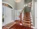 Welcoming foyer with hardwood flooring and a carpeted staircase at 999 Box Turtle Ct, Columbus, IN 47201