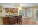 Modern kitchen featuring updated appliances, wooden cabinetry, bar seating and an adjacent dining area at 999 Box Turtle Ct, Columbus, IN 47201
