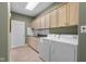 Functional laundry room with washer, dryer, tiled floors, and plenty of storage space at 999 Box Turtle Ct, Columbus, IN 47201
