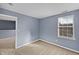 This bedroom features neutral walls, plush carpeting, a window, and doorway at 10432 Dark Star Dr, Indianapolis, IN 46234