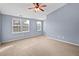 Comfortable bedroom with neutral carpeting, a ceiling fan, and a double window at 10432 Dark Star Dr, Indianapolis, IN 46234