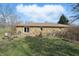 Exterior view of a stone home with a patio, grill, and outdoor seating in a well-maintained backyard at 110 Jordan Ct, Martinsville, IN 46151
