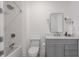 Bathroom featuring a tub and shower, gray vanity with white countertop, decorative mirror and sconces, and patterned flooring at 11003 Holliday Farms Blvd, Zionsville, IN 46077