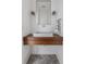 Elegant half bath with a floating wood vanity, a marble sink, a gold trimmed mirror, and stylish sconces at 11003 Holliday Farms Blvd, Zionsville, IN 46077
