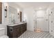 Bright bathroom with a dark wood vanity, white marble countertop, and glass enclosed tiled shower at 11003 Holliday Farms Blvd, Zionsville, IN 46077