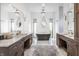 Spacious bathroom with double vanities, marble countertops, a freestanding tub, unique mirrors, and statement lighting at 11003 Holliday Farms Blvd, Zionsville, IN 46077