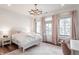 Charming bedroom with a white bed, hardwood floors, soft pink accents, and lots of natural light through multiple windows at 11003 Holliday Farms Blvd, Zionsville, IN 46077
