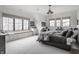 Bright bedroom with large windows, a window seat, a built-in desk, neutral carpet, and modern lighting fixture at 11003 Holliday Farms Blvd, Zionsville, IN 46077