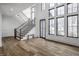 Bright foyer with hardwood flooring, tall windows, a staircase, and a bench, creating an inviting entrance at 11003 Holliday Farms Blvd, Zionsville, IN 46077