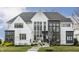 Stunning two-story home with a manicured lawn, complemented by black trimmed windows and a contemporary design at 11003 Holliday Farms Blvd, Zionsville, IN 46077
