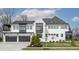 Striking two-story house with a black garage, elegant landscaping, and gray accents at 11003 Holliday Farms Blvd, Zionsville, IN 46077