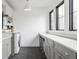 This laundry room has gray shaker cabinets, a white countertop, and black herringbone tile floors at 11003 Holliday Farms Blvd, Zionsville, IN 46077