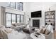 Inviting living room with floor-to-ceiling windows, a cozy fireplace, and stylish, neutral-toned furniture at 11003 Holliday Farms Blvd, Zionsville, IN 46077