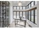 Bright living room with large windows, a modern desk and chair, a stunning wine rack, and hardwood floors at 11003 Holliday Farms Blvd, Zionsville, IN 46077