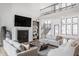 Elegant living room featuring a fireplace, open staircase, and large windows for plenty of natural light at 11003 Holliday Farms Blvd, Zionsville, IN 46077