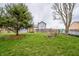 Large grassy backyard with mature trees, a bench, and a wooden fence at 11229 Echo Ridge Ln, Indianapolis, IN 46236
