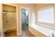 Bathroom featuring a walk-in shower, bathtub, and access to a walk-in closet at 11229 Echo Ridge Ln, Indianapolis, IN 46236
