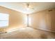 Bright carpeted bedroom featuring a ceiling fan, a window, and a door to the back at 11229 Echo Ridge Ln, Indianapolis, IN 46236