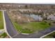 Aerial view of a lush pond surrounded by green space and flowering trees in a residential neighborhood at 11475 Clay Ct # 102, Fishers, IN 46037