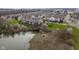Aerial view showcasing a scenic pond surrounded by townhomes and green spaces at 11475 Clay Ct # 102, Fishers, IN 46037
