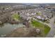 Aerial view of a residential community with a pond and lush landscaping on an overcast day at 11475 Clay Ct # 102, Fishers, IN 46037