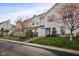 Exterior view of townhomes with well-kept lawns and mature trees lining the street at 11475 Clay Ct # 102, Fishers, IN 46037