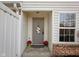 Inviting front door with a wreath, potted flowers, and a doormat at 11475 Clay Ct # 102, Fishers, IN 46037