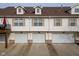 Row of townhome garages with white doors and matching siding for a clean, uniform look at 11475 Clay Ct # 102, Fishers, IN 46037